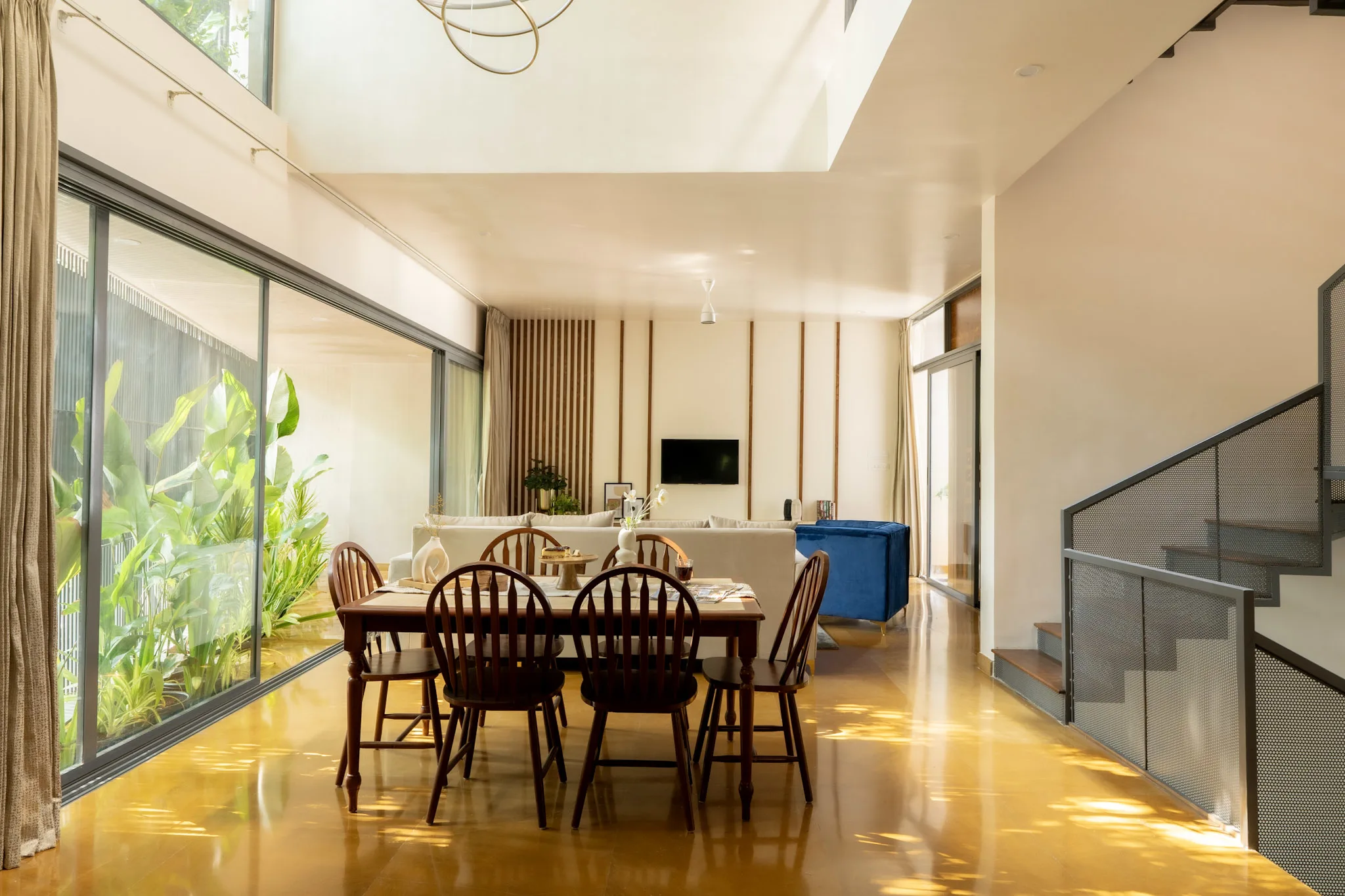 Open plan dining and living room with staircase and double height ceiling