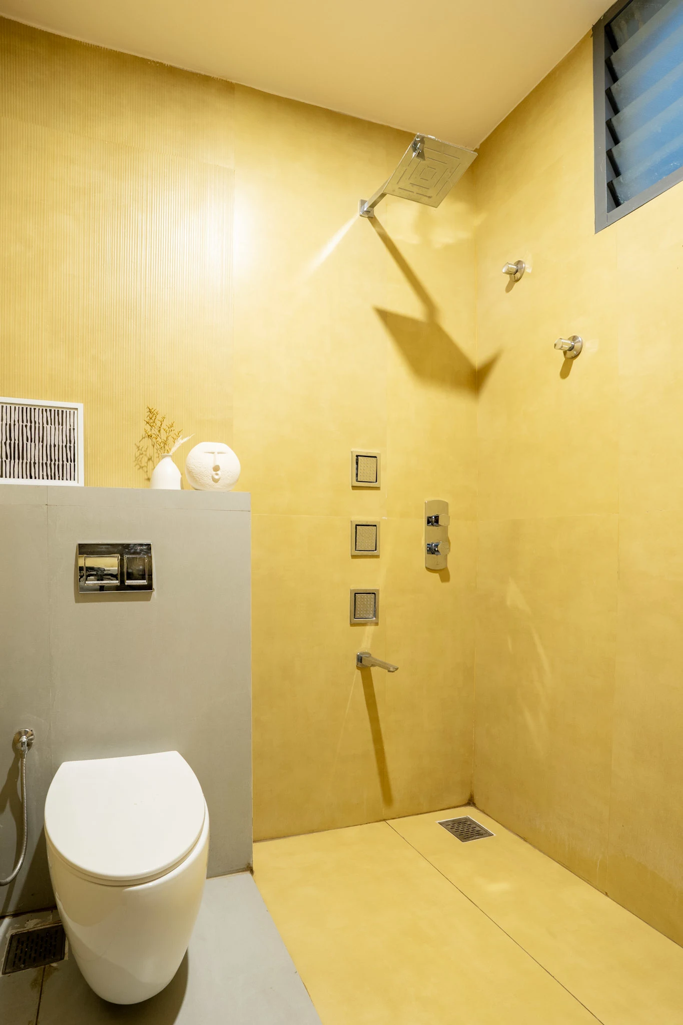 Minimal yellow bathroom design with rainfall shower and modern fittings