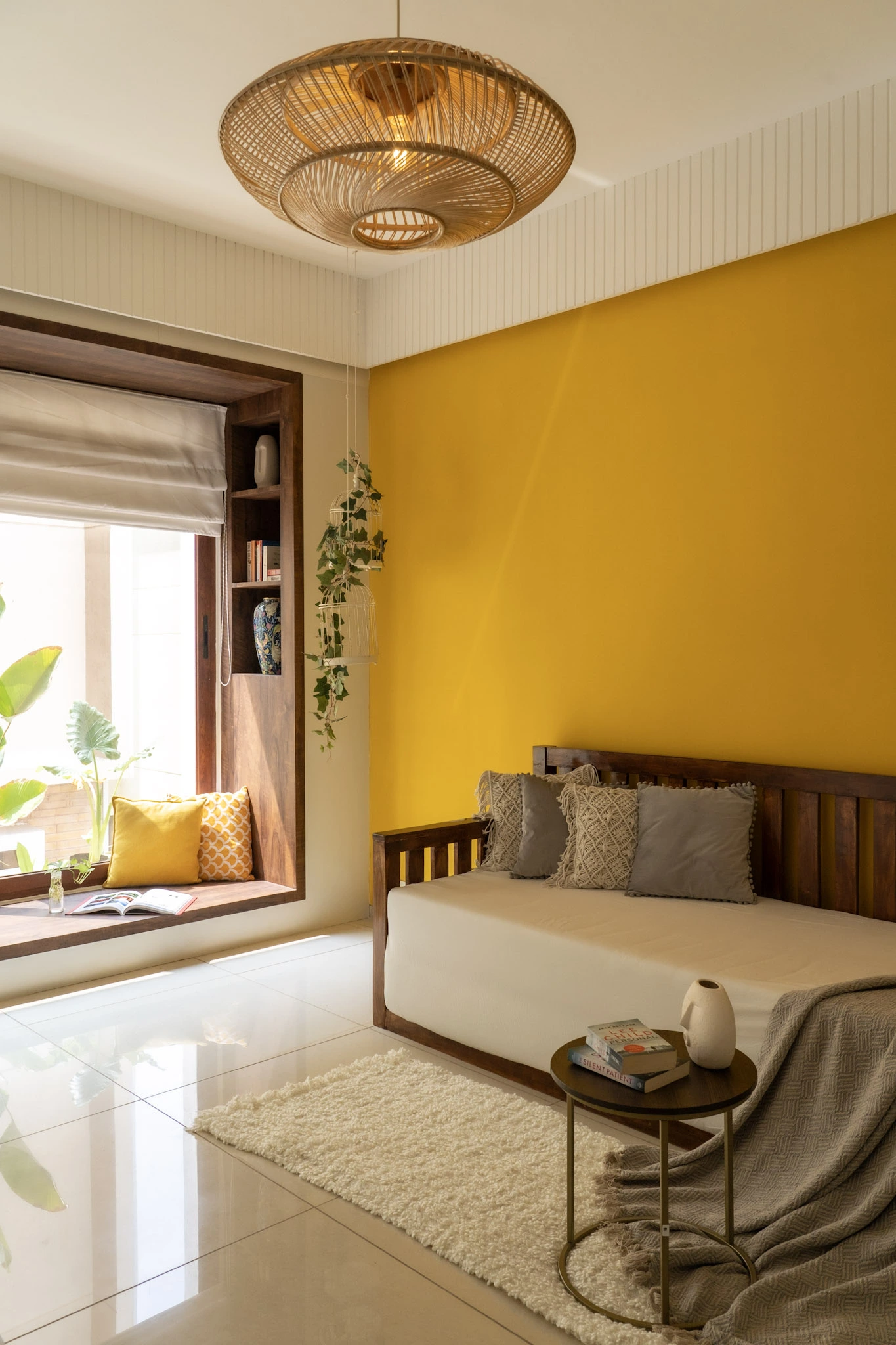 Modern sitting area with wooden daybed, yellow wall design, pendant lighting, and window seating