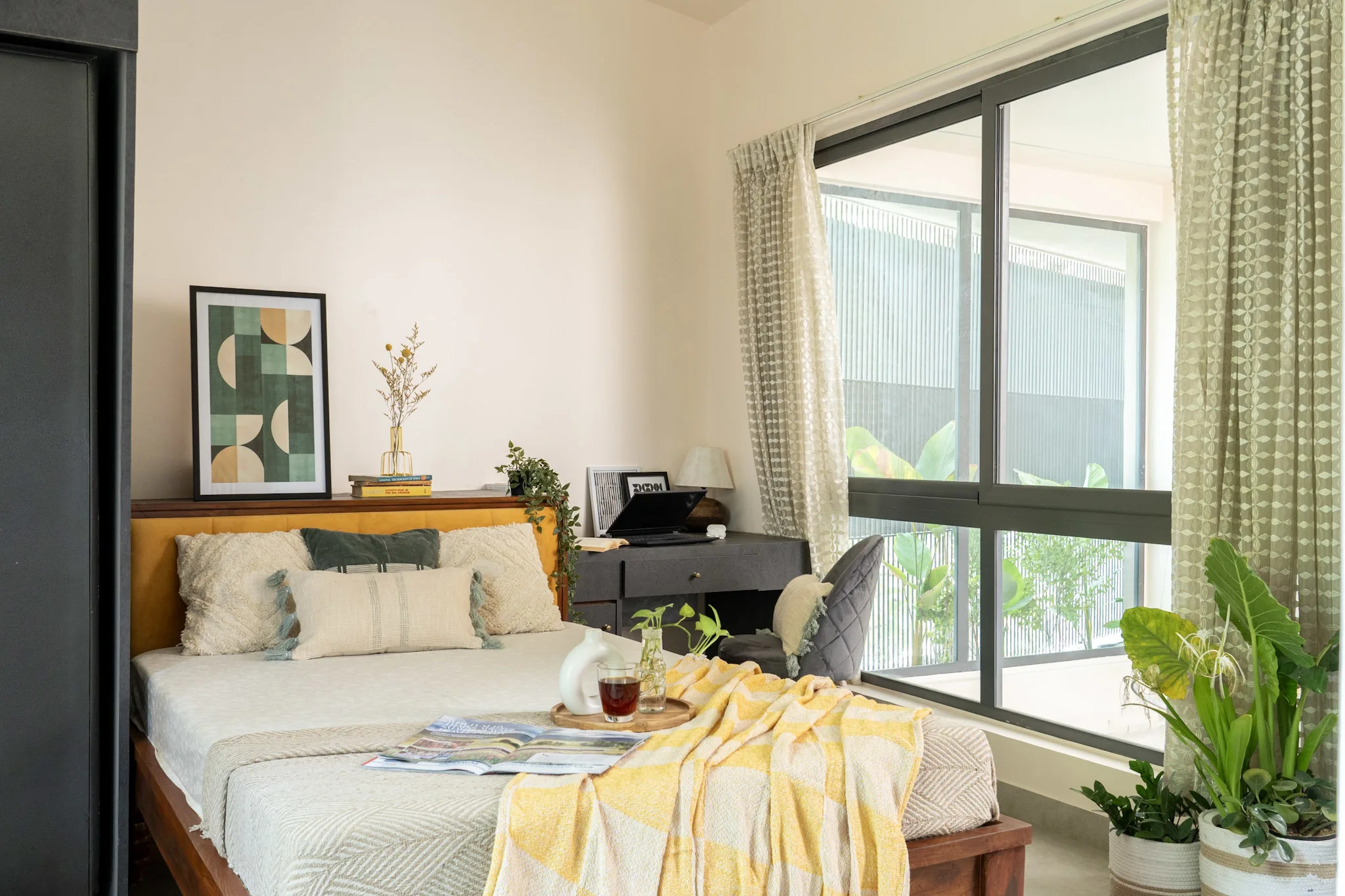 Contemporary bedroom interior with study desk, indoor plants and large glass window