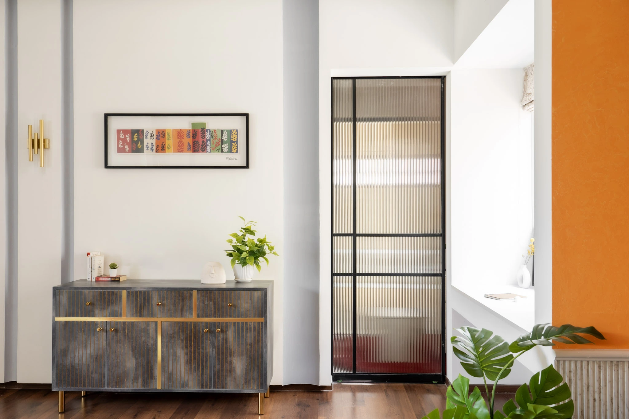 Luxury villa hallway with designer console cabinet, indoor plants, and modern glass partition door