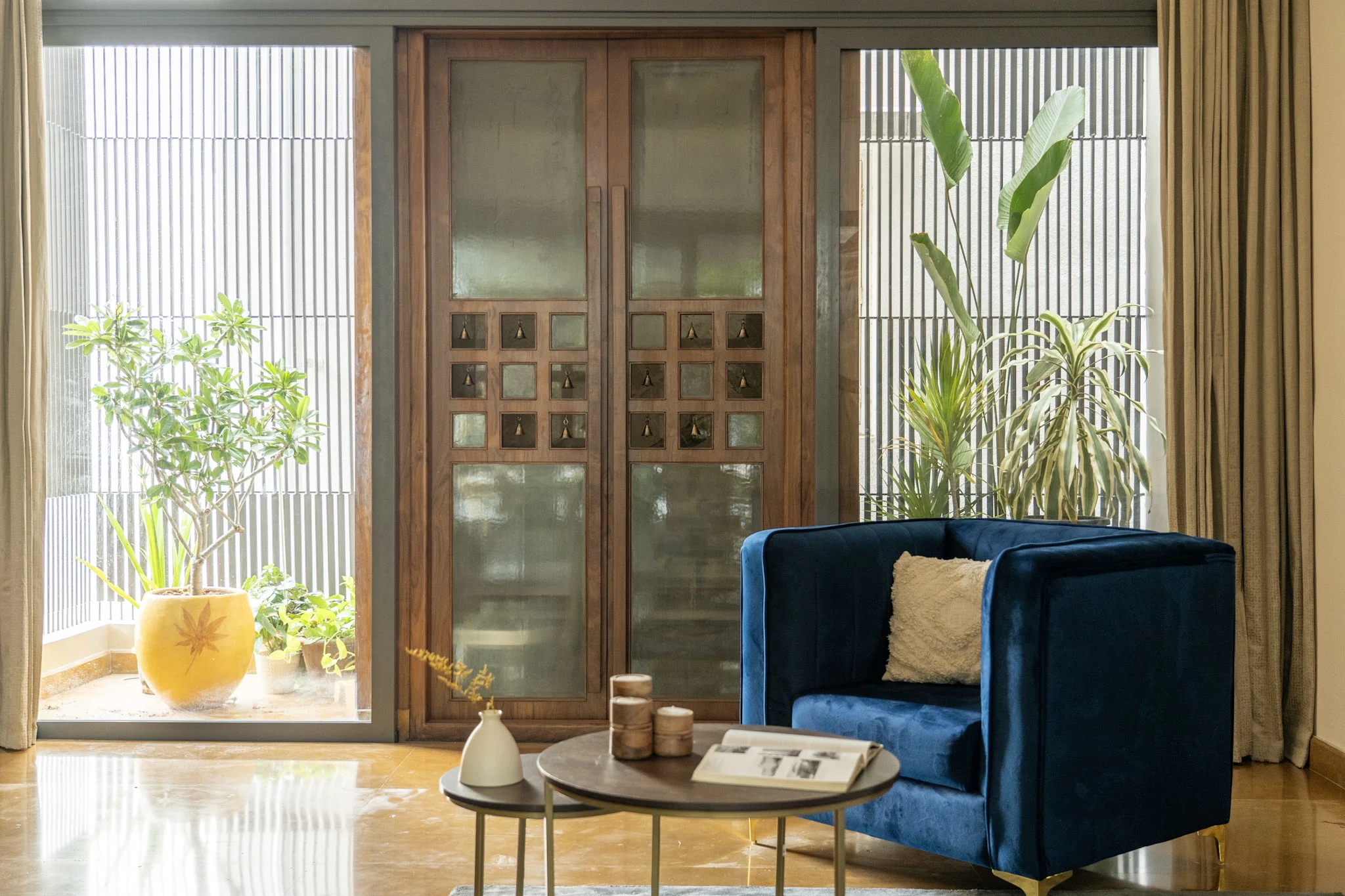 Contemporary entrance seating area with blue armchair and wooden main door design
