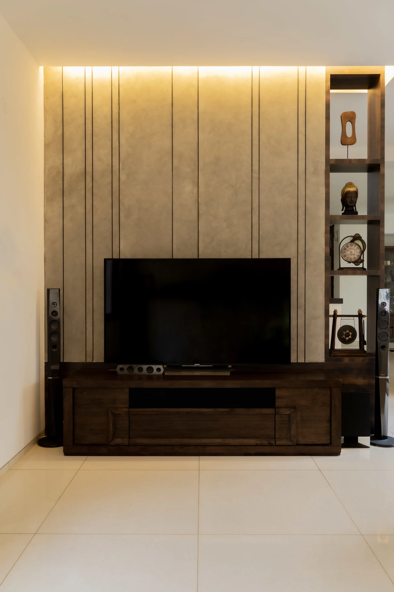 Contemporary TV unit design with wooden media console, textured wall panel, and ambient lighting