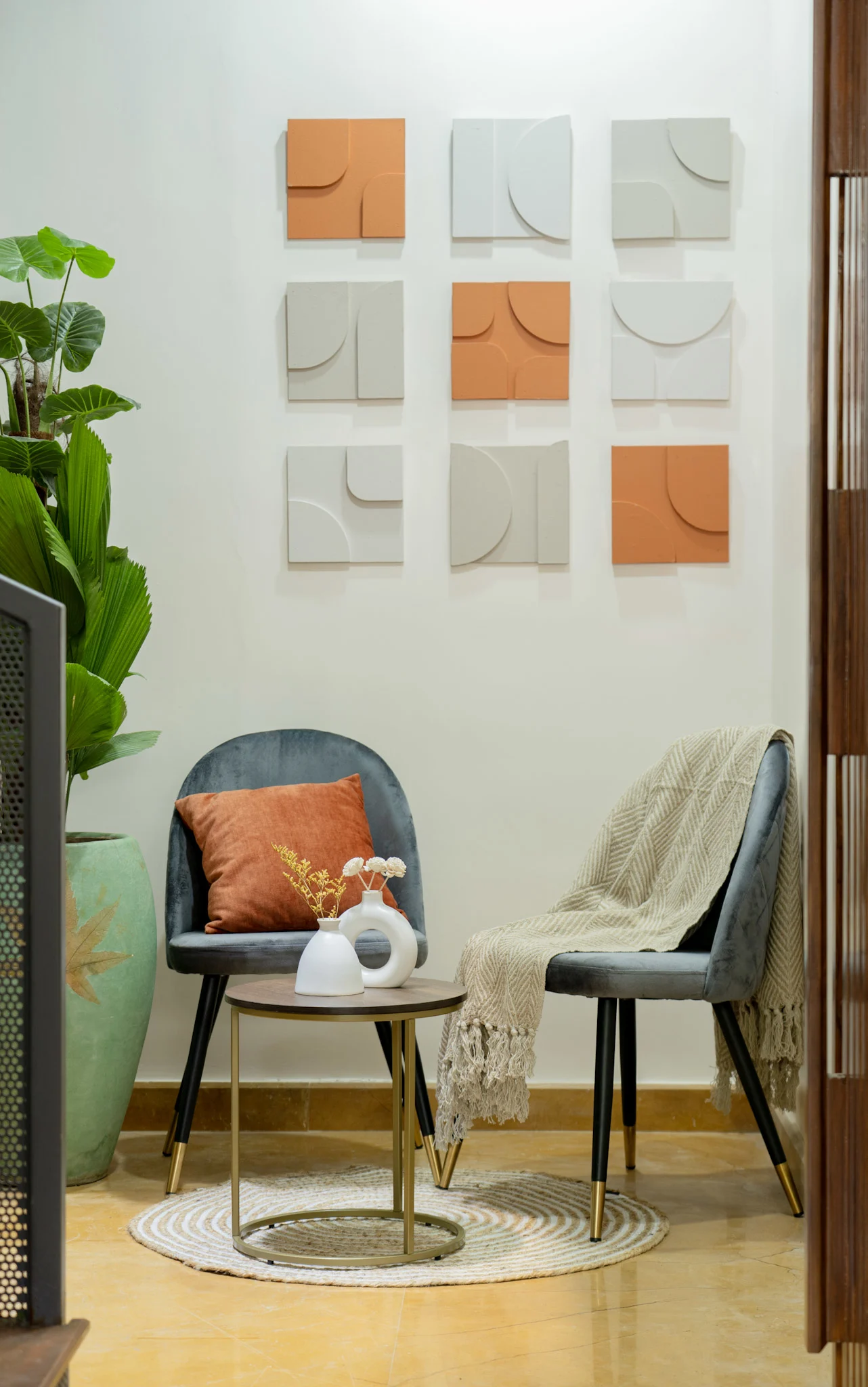 Cozy seating corner with accent chairs, wall art and round coffee table in modern villa