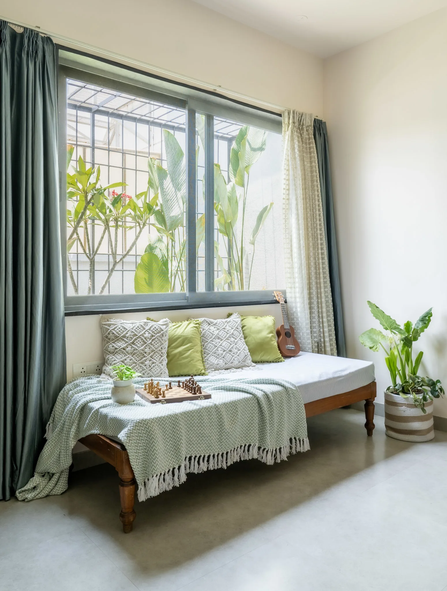 Modern bedroom with large window seating, indoor plants and minimalist wooden furniture