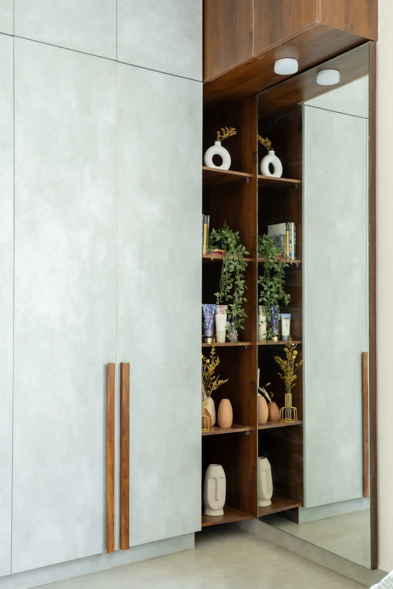 Modern wardrobe design with grey laminate finish, wooden shelves and full length mirror